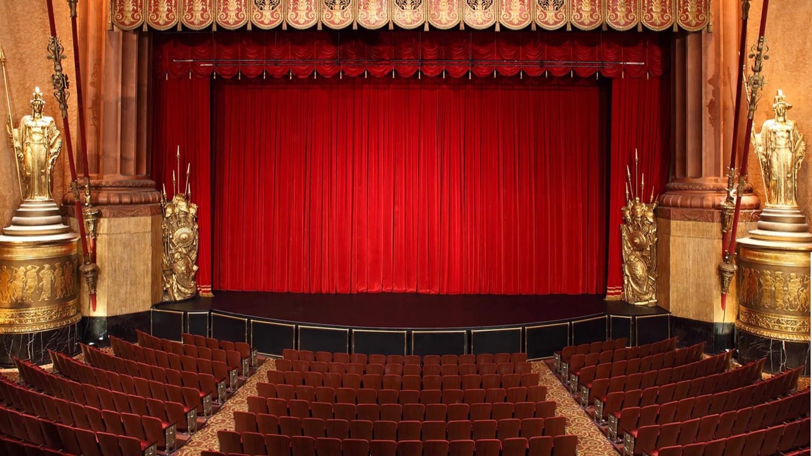 A theatre auditorium with the red curtain closed